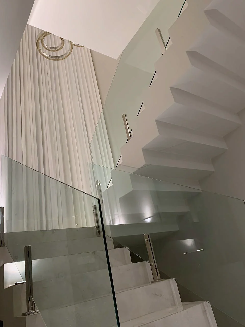 Cortina sob medida em pé direito duplo ao lado da escada com guarda-corpo de vidro, Artmari Decor SC